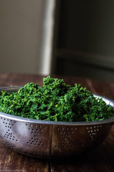 A pot of dark green stew simmering on the stove